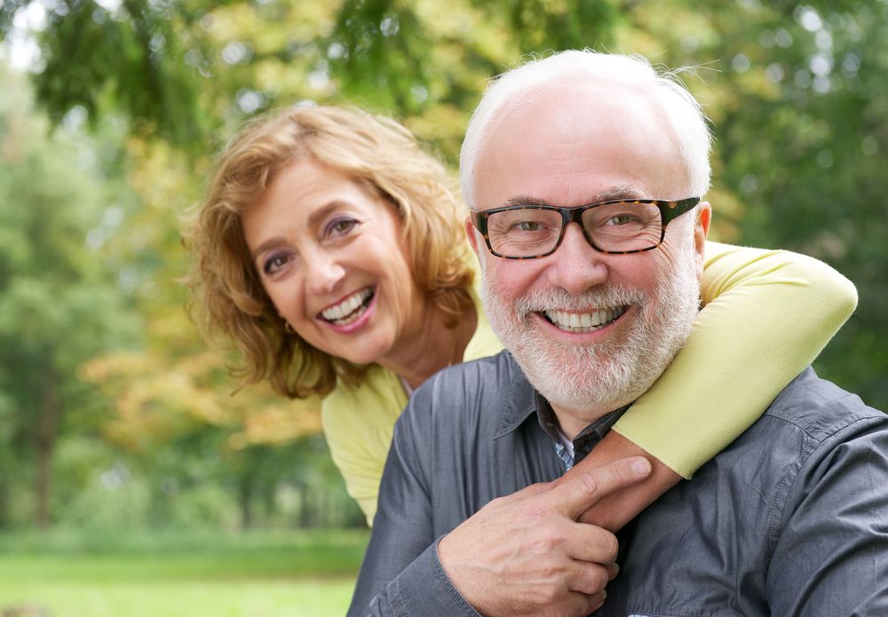 man smiling with his wife after getting dental implants at Creative Smiles Dentistry in Tucson, AZ