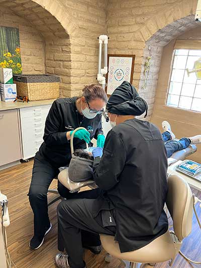 Dr. Ju placing dental veneers on a patient sitting in dental chair
