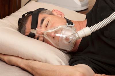 sleep apnea patient resting with a CPAP machine